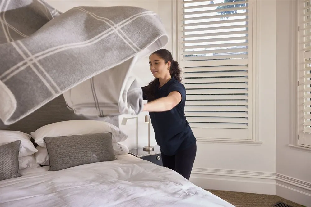 Spruce cleaner making a bed with fresh linen