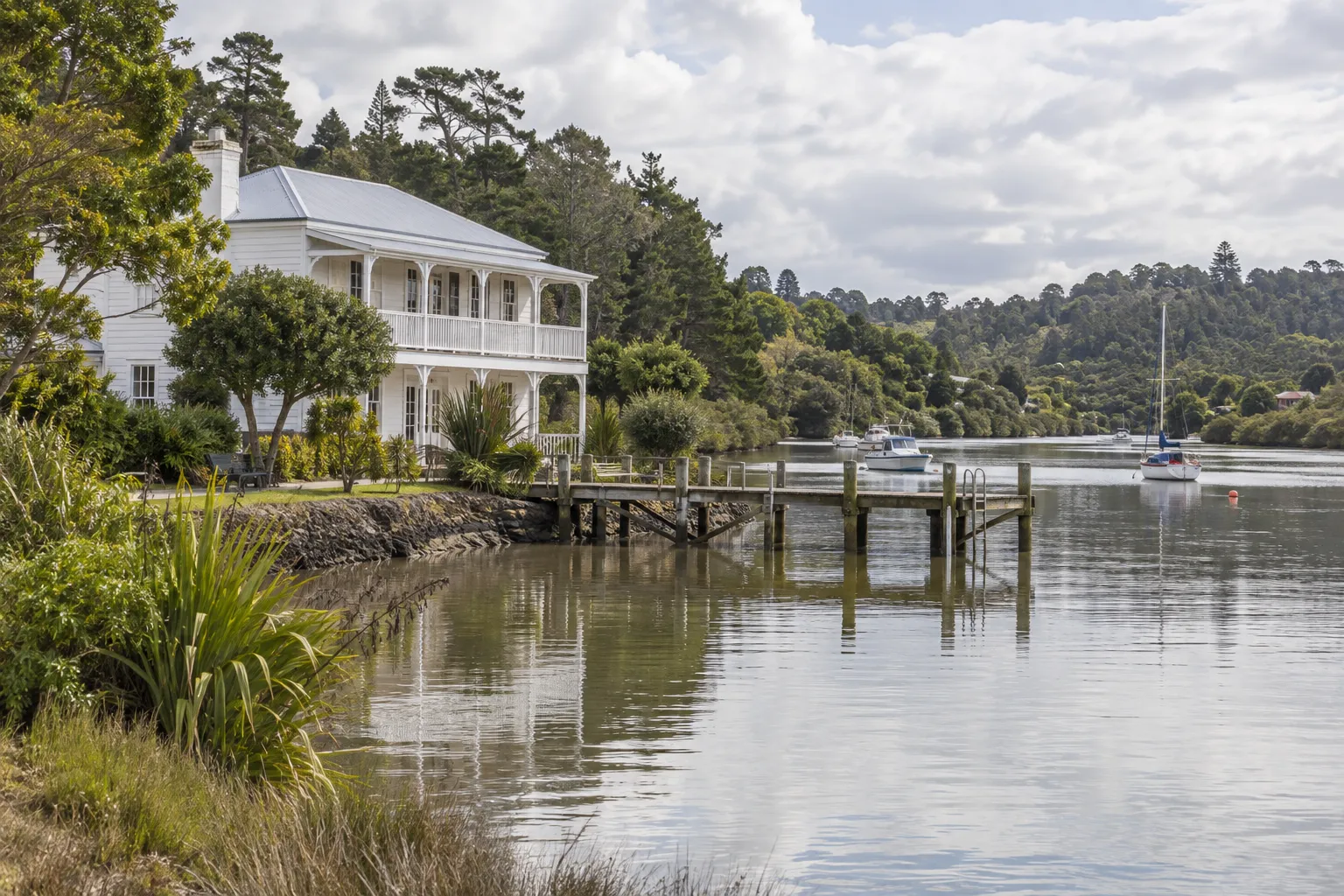 Historic timber riverside building and jetty on the Upper Waitematā River at Riverhead